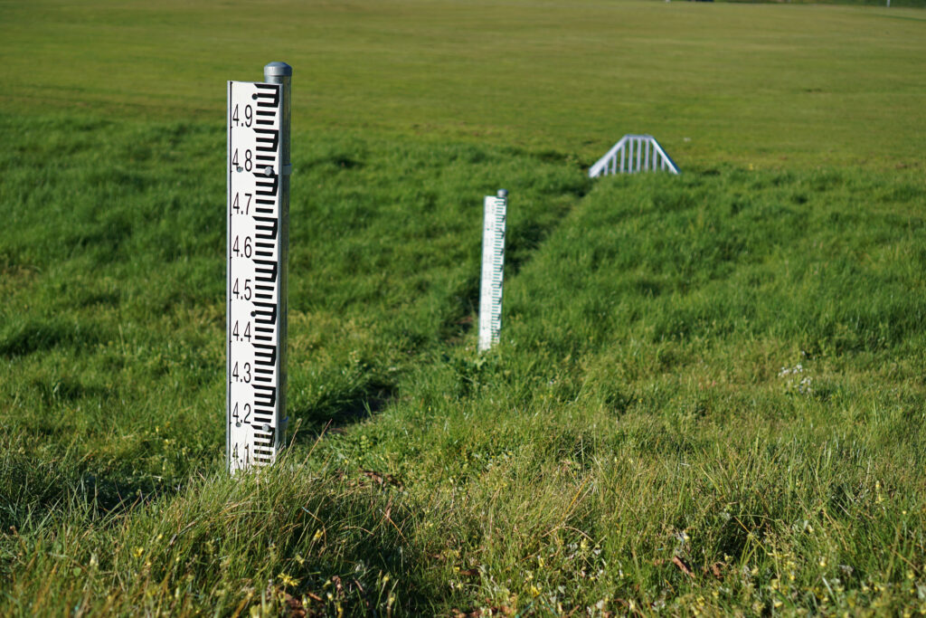 Environmental Monitoring photo of industrial measuring rulers in large grassy field