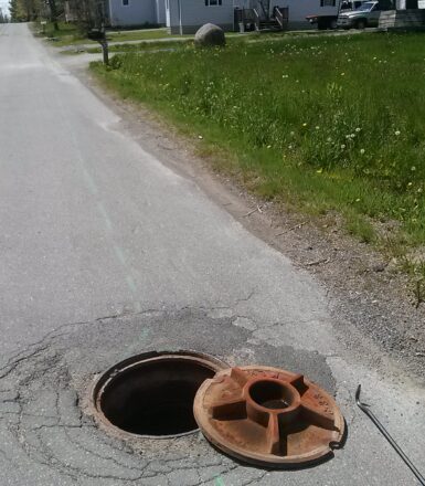 photo of road manhole cover removed from manhole