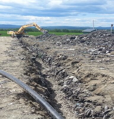 photo of an excavator digging a long ditch
