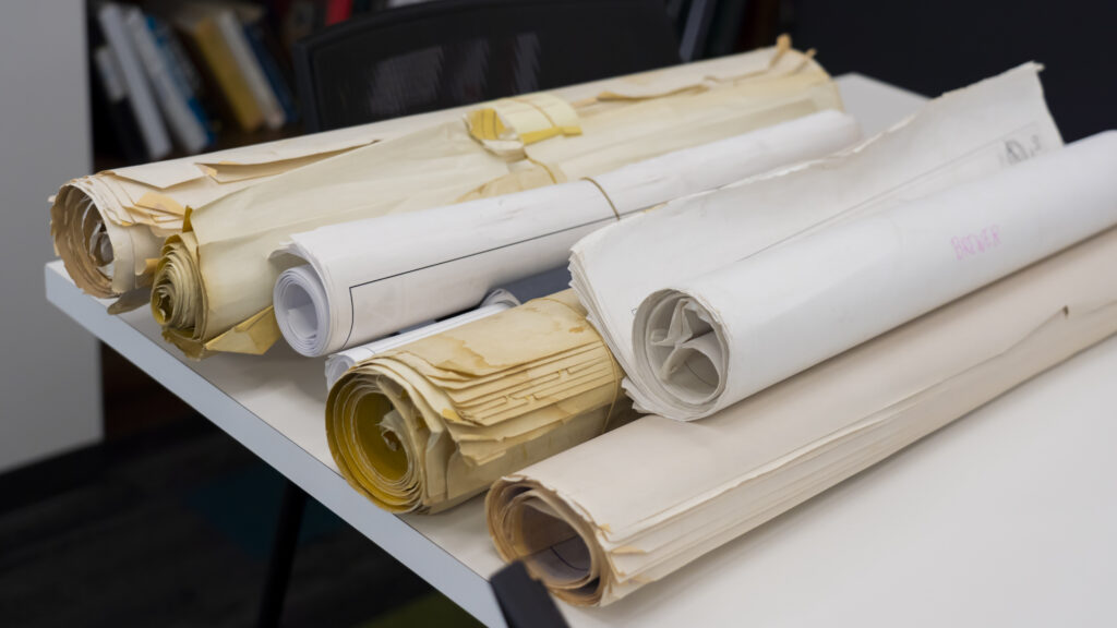 Home photo of large rolled up papers on table in office