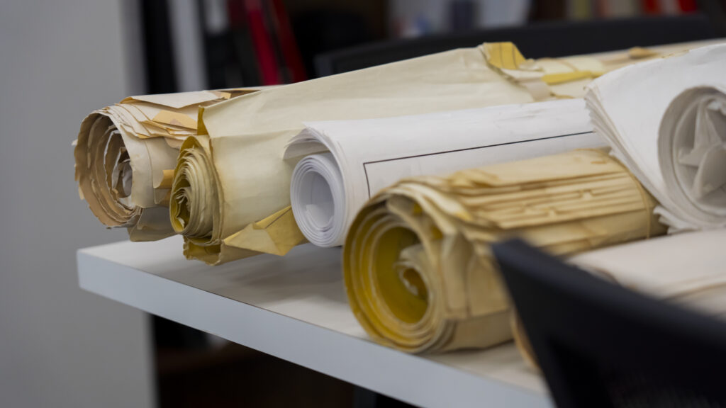 Architectural Design up close photo of large rolled up papers on table in office