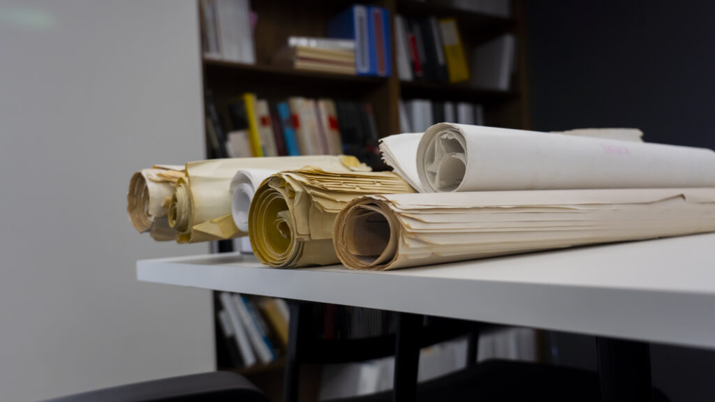 Bid Room photo of large rolled up papers on table in office